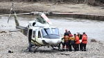 Quebec's workplace safety board says a lack of training and equipment contributed to the deaths of two firefighters during a May 2023 flood northeast of Quebec City. Rescuers carry the body of one of the two missing firefighters to a helicopter, in Baie-Saint-Paul, Que. Wednesday, May 3, 2023. THE CANADIAN PRESS/Jacques Boissinot
