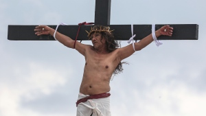 Ruben Enaje remains on the cross during the reenactment of Jesus Christ's sufferings as part of Good Friday rituals in San Pedro Cutud, north of Manila, Philippines, Friday, March 29, 2024. (AP Photo / Gerard V. Carreon)