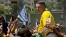 Brazil's former President Jair Bolsonaro is surrounded by supporters after attending a campaign event launching the pre-candidacy of a mayoral candidate, in Rio de Janeiro, Brazil, March 16, 2024. (AP Photo/Silvia Izquierdo, File) 