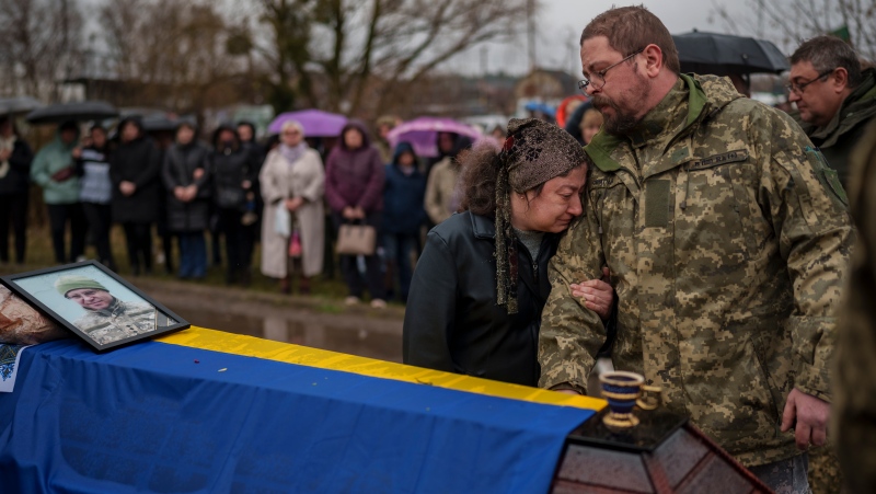 Relatives cry next to the coffin of Ukrainian Cpt. Serhii Vatsko in Boiarka, Ukraine, Friday, March 29, 2024. (AP Photo/Vadim Ghirda)