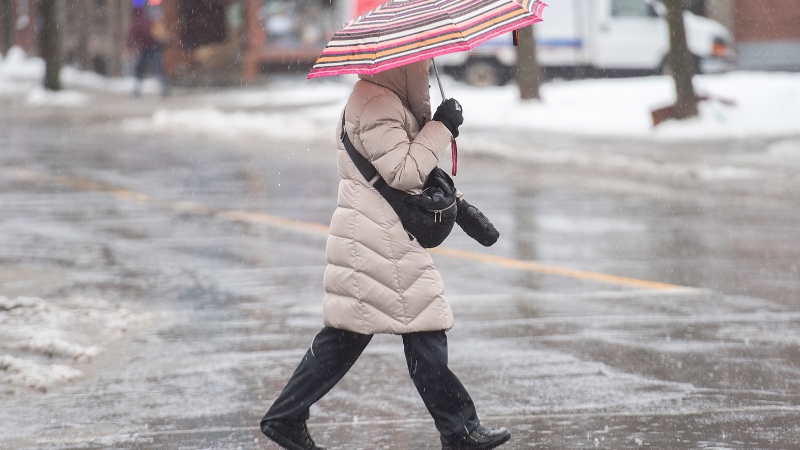 A person holds an umbrella as rain falls in Montreal. (Graham Hughes/The Canadian Press)