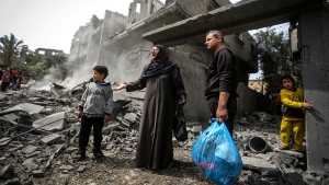 Palestinians collect their belongings from the rubble of a residential building for the Moussa family after an Israeli airstrike in the Maghazi refugee camp, central Gaza Strip, Friday, March 29, 2024. (AP Photo / Ismael Abu Dayyah)