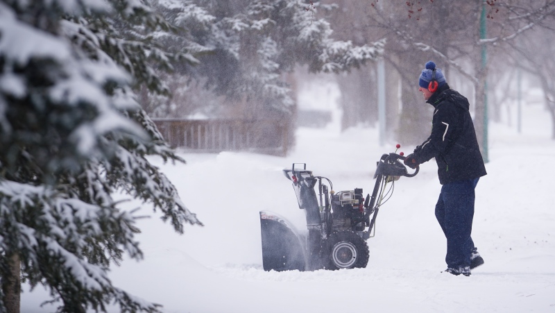 A person pushes a snowblower in Saskatoon, Sask., Monday, Feb. 26, 2024. Environment Canada has issued a Winter Storm Warning for Saskatoon as an Alberta clipper tracks across the Prairies. (THE CANADIAN PRESS/Heywood Yu)