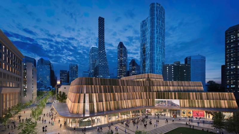 An exterior nighttime rendering shows the Arts Commons Transformation expansion’s curved form, exterior cladding, and interior finishes inspired by Alberta’s dramatic landscapes and the regional lodge typologies. (CMLC) 