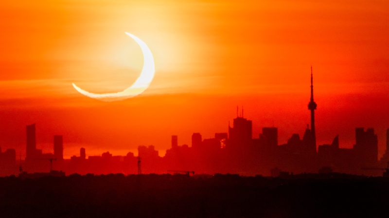 An annular solar eclipse rises over the skyline of Toronto on Thursday, June 10, 2021. (The Canadian Press/Frank Gunn)