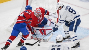Toronto Maple Leafs' John Tavares (91) moves in on Montreal Canadiens goaltender Cayden Primeau as Canadiens' Jordan Harris (54) defends during second period NHL hockey action in Montreal, Saturday, April 6, 2024. (Graham Hughes, The Canadian Press)
