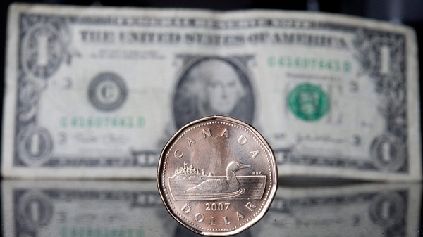 A Canadian dollar, or loonie, sits in front of the American dollar in Ottawa, Thursday Sept. 20, 2007. (Jonathan Hayward / THE CANADIAN PRESS)