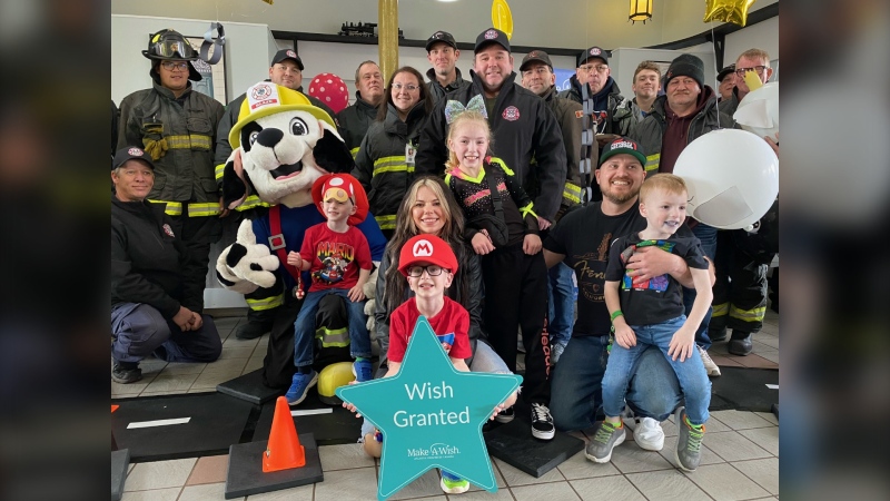 Sebastian Bobra and his siblings pose for a photo with members from the local fire department at the Amherst Train Station in Amherst, N.S. (CTV/Derek Haggett)