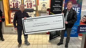 Timmins MPP George Pirie (right) announced that the province is investing $330,000 in the South Porcupine Arena Association to upgrade the Carlo Cattarello Arena and presented the ceremonial cheque to arena manager and association member Burt St-Amour (left) on April 7, 2024. (Supplied/Office of George Pirie)
