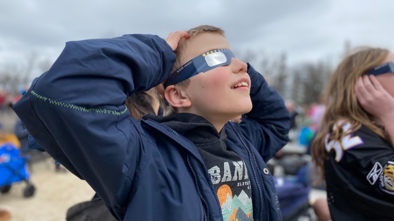 Sean Terichow Parrott, 11, gazes at the partial solar eclipse while wearing safety glasses during a watch party at The Leaf on April 8, 2024 (Danton Unger/CTV News Winnipeg)