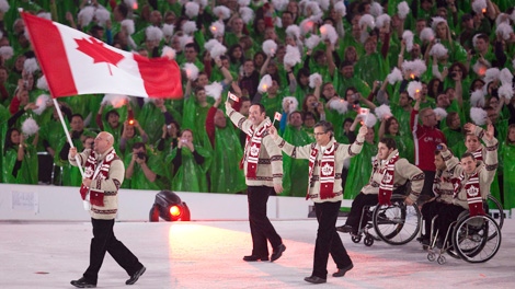Canada's Jean Labonte carries the Canadian flag during the opening ceremonies of the Winter Paralympic Games in Vancouver, Friday, March 12, 2010. (CP/Jonathan Hayward)