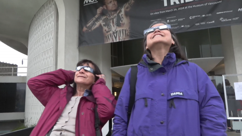 Hopeful eclipse-watchers stand outside the H.R. McMillan Space Centre in Vancouver on April 8, 2024. 