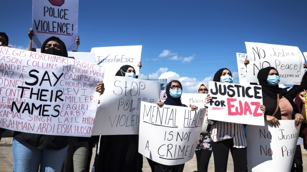 People hold signs outside Peel Regional Police Headquarters during a justice rally for Ejaz Choudry, a 62-year-old man who was shot and killed by police, in Mississauga, Ont., on Saturday, June 27, 2020. THE CANADIAN PRESS/ Tijana Martin