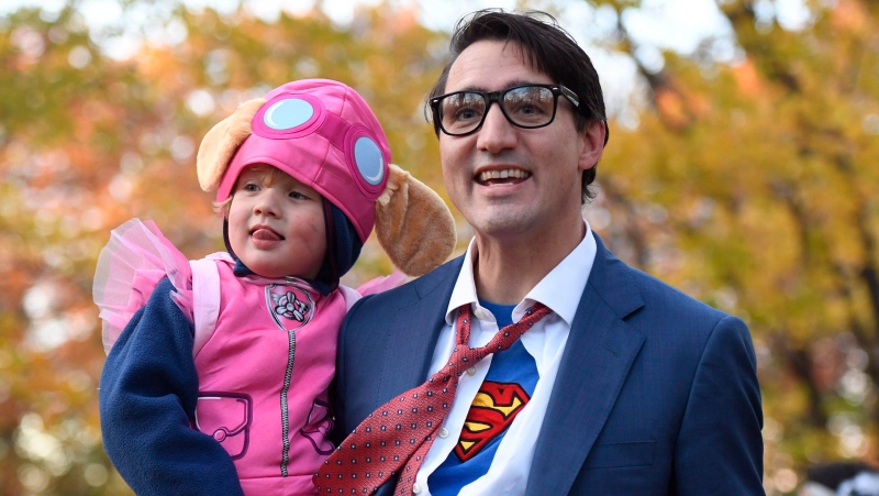 Prime Minister Justin Trudeau, dressed as DC Comics character Clark Kent, holds his son Hadrien as they go trick-or-treating at Rideau Hall on Halloween in Ottawa on Oct. 31, 2017 (Justin Tang / THE CANADIAN PRESS)