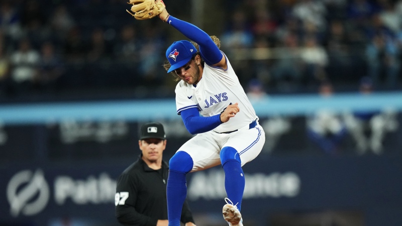 Toronto Blue Jays shortstop Bo Bichette (11) makes a leaping grab on a high cut-off throw against the Seattle Mariners during ninth inning American League MLB baseball action in Toronto on Monday, April 8, 2024. THE CANADIAN PRESS/Nathan Denette