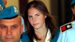 In this Sept. 26, 2008 Amanda Knox, centre, is escorted by Italian penitentiary police officers to Perugia's court. (AP Photo / Pier Paolo Cito, File)