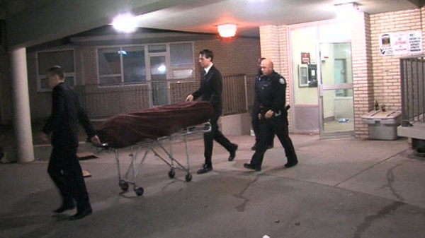 The body of the homicide victim is removed from an apartment at 4010 Lawrence Avenue East.
