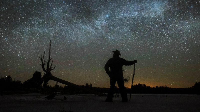 Stargazer Dave Cooke observes an unusual placement of the Milky Way, over a frozen fish sanctuary in central Ontario, north of Hwy 36 in Kawartha Lakes, Ont., on Sunday, March 21, 2021. THE CANADIAN PRESS/Fred Thornhill