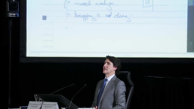 Documents are displayed on a screen behind Prime Minister Justin Trudeau as he appears as a witness at the Public Inquiry Into Foreign Interference in Federal Electoral Processes and Democratic Institutions in Ottawa on Wednesday, April 10, 2024. (THE CANADIAN PRESS/Sean Kilpatrick)