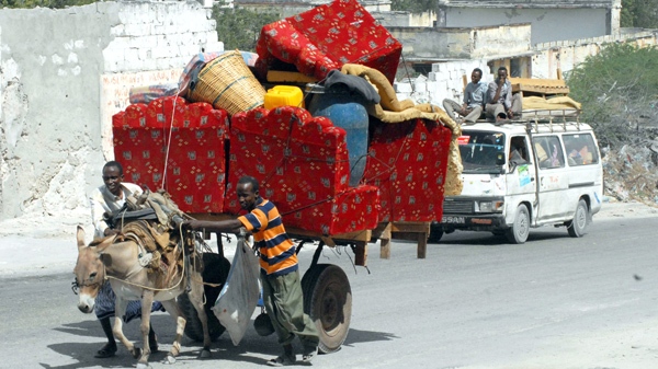 Residents load their belongings onto a donkey cart and a minibus as they flee their neighborhood in the capital, Mogadishu, Somalia, where intense fighting broke out for the third day between Somali government forces backed the AU forces and Islamist insurgents on Friday March 12, 2010. (AP / Farh Abdi Warsameh)