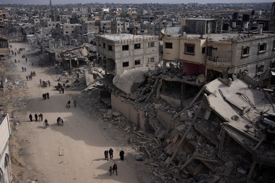 Palestinians walk through destruction in Gaza