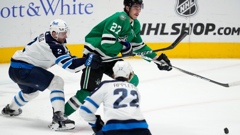 Dallas Stars left wing Mason Marchment (27) looks to pass the puck as Winnipeg Jets' Dylan DeMelo (2) and Jets' Mason Appleton (22) defend in the third period of an NHL hockey game in Dallas, Thursday, April 11, 2024. (AP Photo/Tony Gutierrez)