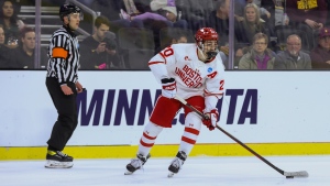 Boston University's Lane Hutson (20) looks to pass the puck during the third period of a regional final against Minnesota in the men's NCAA college hockey tournament, Saturday, March 30, 2024, in Sioux Falls, S.D. (Josh Jurgens, The Associated Press)