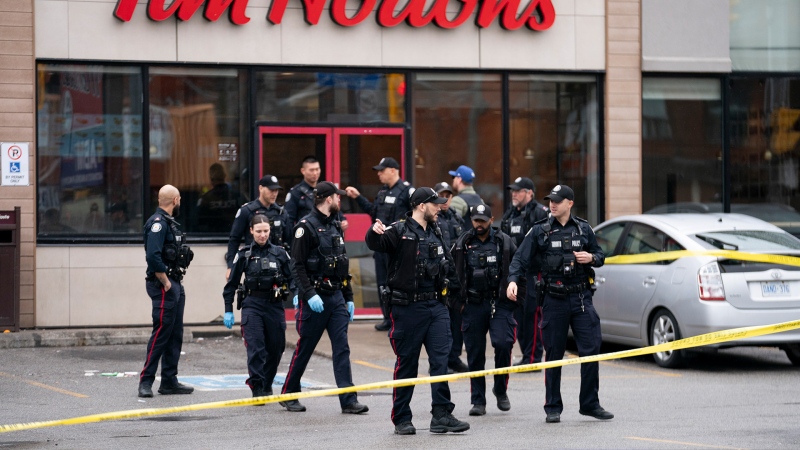 Toronto Police work the scene where a police officer was stabbed and a suspect shot in Toronto on Friday, April 12, 2024. THE CANADIAN PRESS/Arlyn McAdorey