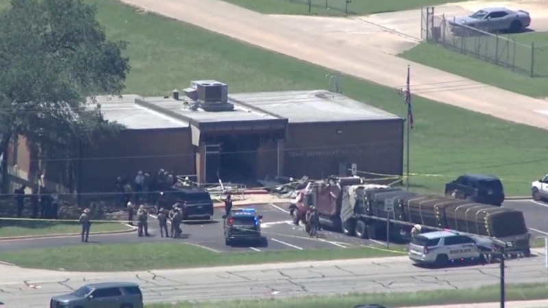 Emergency personnel arrive on the scene after a an 18-wheeler crashed into the Texas Department of Public Safety Office in Brenham, Texas on Friday, April 12, 2024. (KTRK via AP)