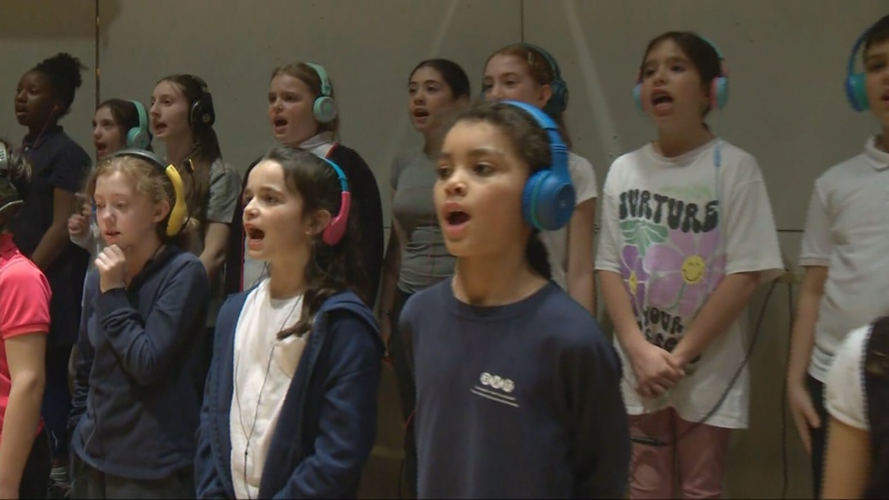 A group of children from the English Montreal School Board perform 'The Adventures of Eva the Louse,' an ambitious multimedia project using a 40-piece orchestra. (CTV News)