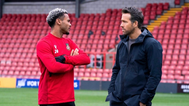 This image released by FX shows Dior Angus, left, and Ryan Reynolds in a scene from the docuseries "Welcome to Wrexham," which follows owners Reynolds and Rob McElhenney as they take over the lower-league Welsh soccer team Wrexham AFC. (Patrick McElhenney/FX via AP)
