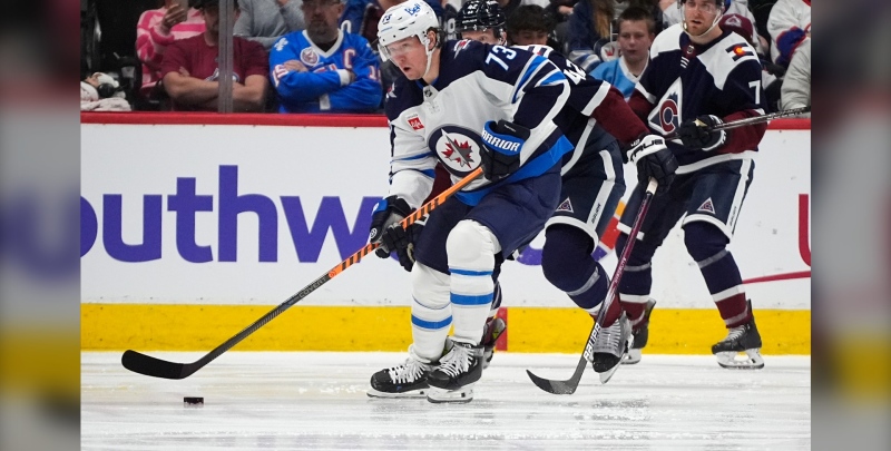 Winnipeg Jets center Tyler Toffoli collects the puck as Colorado Avalanche defensemen Josh Manson, center, and Devon Toews, right, cover in the third period of an NHL hockey game Saturday, April 13, 2024, in Denver. (AP Photo/David Zalubowski)