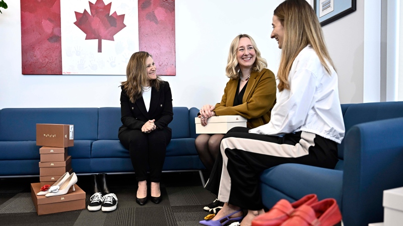 Deputy Prime Minister and Minister of Finance Chrystia Freeland tries on a pair of shoes from direct-to-consumer footwear company Maguire during a pre-budget photo op in her office in Ottawa, Monday, April 15, 2024. (Justin Tang/Canadian Press)