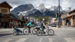 Cyclists ride through downtown Canmore, Alta., Monday, April 24, 2023.THE CANADIAN PRESS/Jeff McIntosh