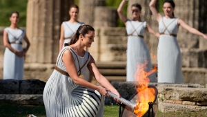 Greek actress Xanthi Georgiou, playing the role of the high priestess, lights the torch during the lighting of the Olympic flame at Ancient Olympia site, birthplace of the ancient Olympics in southwestern Greece Oct. 18, 2021. (AP Photo/Thanassis Stavrakis)