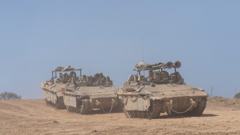 Israeli soldiers drive personnel carriers