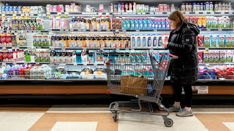 Stefani Balinsky checks prices as she shops in her local grocery store in Montreal, Wednesday March 27, 2024. THE CANADIAN PRESS/Christinne Muschi