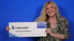 Julie Esson a 55-year-old woman from Alliston Ont., holds her $1 million lottery win from the March., 6, 2024 draw. (OLG)