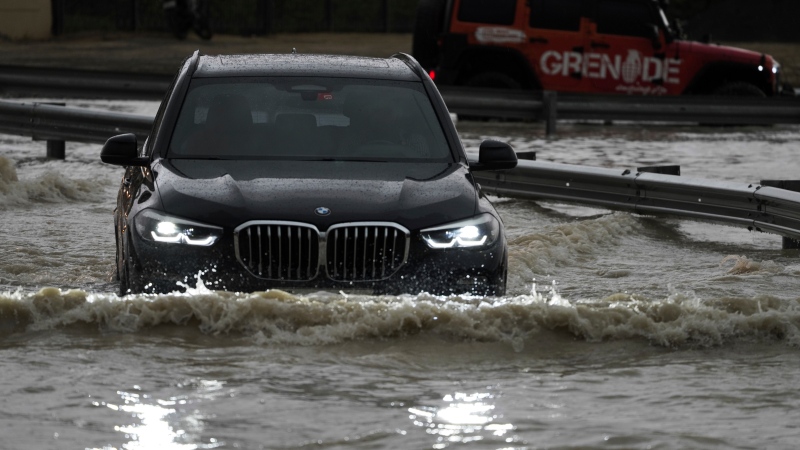 An SUV stalls out while trying to pass through standing water in Dubai, United Arab Emirates, Tuesday, April 16, 2024. (AP Photo / Jon Gambrell)