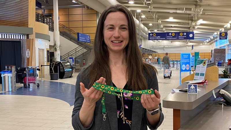 Courtney Burns, president and CEO of the Greater Moncton International Airport Authority, holds a hidden disabilities sunflower lanyard. (Alana Pickrell/CTV Atlantic)