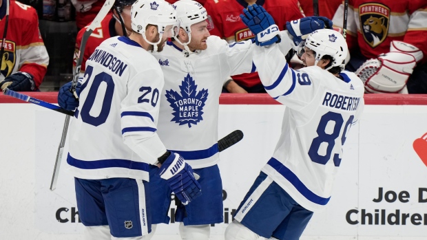 Toronto Maple Leafs center Noah Gregor, center, is congratulated by defenseman Joel Edmundson (20) and left wing Nicholas Robertson (89) after Gregor scored during the first period of an NHL hockey game against the Florida Panthers, Tuesday, April 16, 2024, in Sunrise, Fla. (AP Photo/Wilfredo Lee)