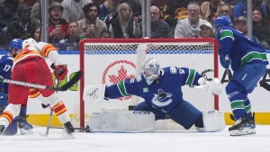 Vancouver Canucks goalie Thatcher Demko (35) stops Calgary Flames' Martin Pospisil, front left, during the second period of an NHL hockey game in Vancouver, on Tuesday, April 16, 2024. THE CANADIAN PRESS/Darryl Dyck