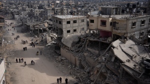 Palestinians walk through the destruction in the wake of an Israeli air and ground offensive in Khan Younis, southern Gaza Strip, Monday, April 8, 2024. (AP Photo/Fatima Shbair)
