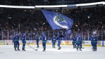 Vancouver Canucks players gather at centre ice to raise their sticks to the fans after defeating the Calgary Flames during their final NHL regular season home hockey game, in Vancouver, on Tuesday, April 16, 2024. THE CANADIAN PRESS/Darryl Dyck