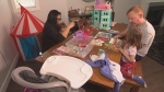 Adam and Maria Reynolds play with their two children in their condo home. With a third child on the way, they're nervous about making ends meet financially. (Garry Barndt, CTV News)