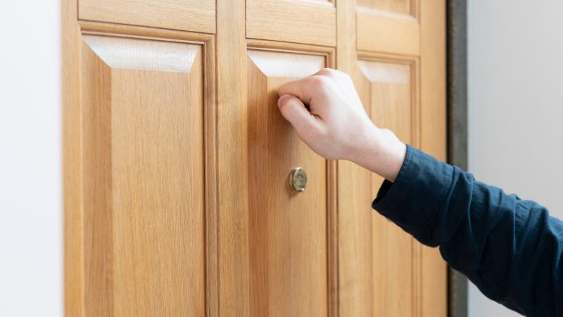 A person is seen knocking on a door in this undated stock image. (Shutterstock)