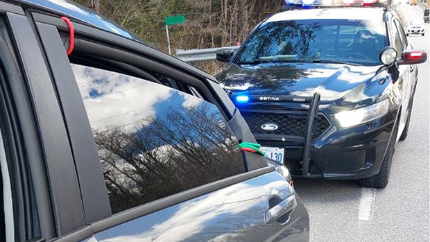 Police pull over a vehicle with a door being held closed by bungee cords in Caledon, Ont., on Wed., April 17, 2024. (Source: OPP)