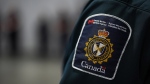 A patch is seen on the shoulder of a Canada Border Services Agency officer's uniform as he listens during an announcement about a seizure of opium, in Tsawwassen, B.C., Friday, Dec. 16, 2022. The CBSA says the nearly 2,500 kilograms of opium found within 247 shipping pallets inside marine containers is the largest seizure of opium to date for the agency. THE CANADIAN PRESS/Darryl Dyck