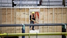 An employee works on a modular home component in Calgary, Friday, April 5, 2024. (Jeff McIntosh/The Canadian Press)