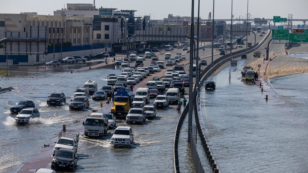 Vehicles drive through standing floodwater caused by heavy rain in Dubai, United Arab Emirates, Thursday, April 18, 2024. (AP Photo/Christopher Pike)